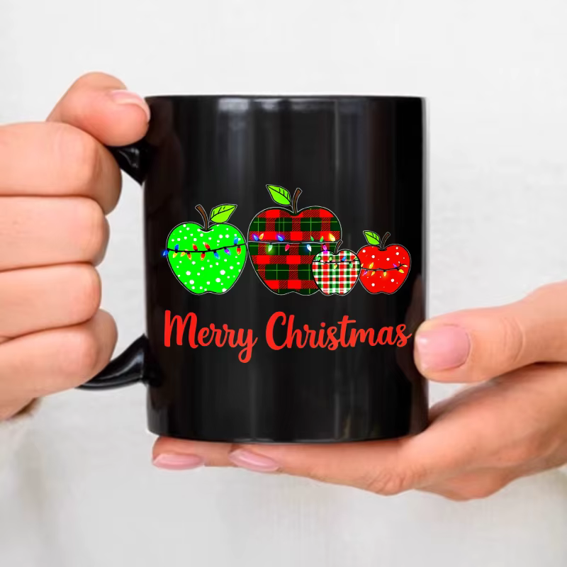 Tasse à café noire avec motif pomme de Noël et texte "Joyeux Noël", parfaite pour la saison des fête